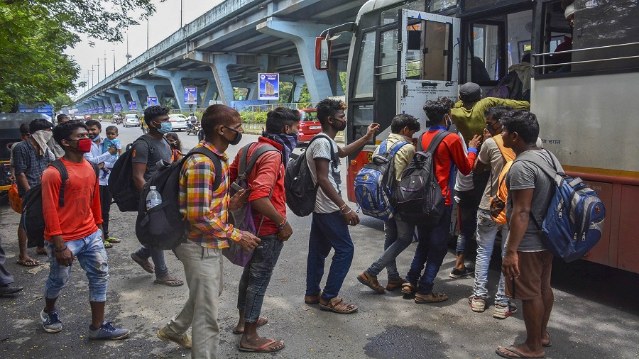 Migrant workers returning from their native places board a bus in Thane travelling towards Mumbai