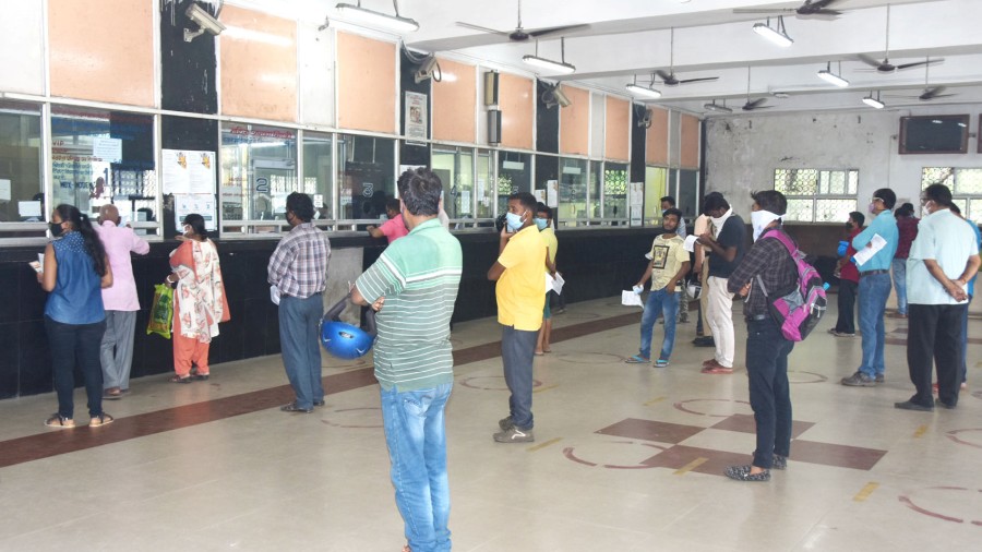 People wait for their turn to buy tickets at Dhanbad railway station on Thursday.