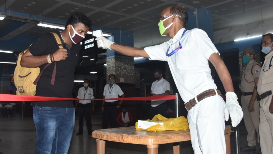 Officials conduct thermal scanning of passengers before they are allowed to enter the platform at Dhanbad railway station on Saturday.