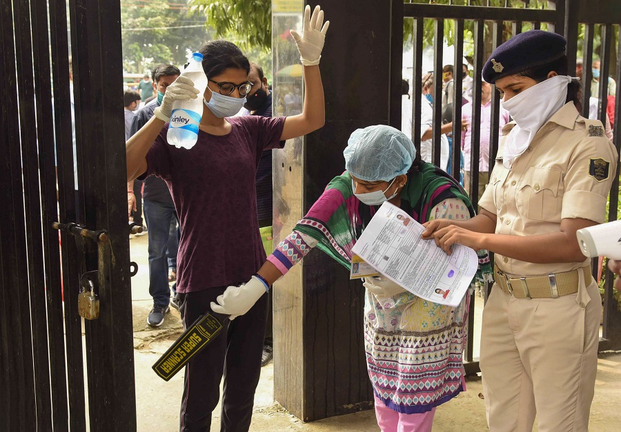 Candidates undergo a security check before entering an examination centre for the National Eligibility-Cum-Entrance Test (NEET), during unlock 4.0, in Patna, Sunday, Sept. 13, 2020.
