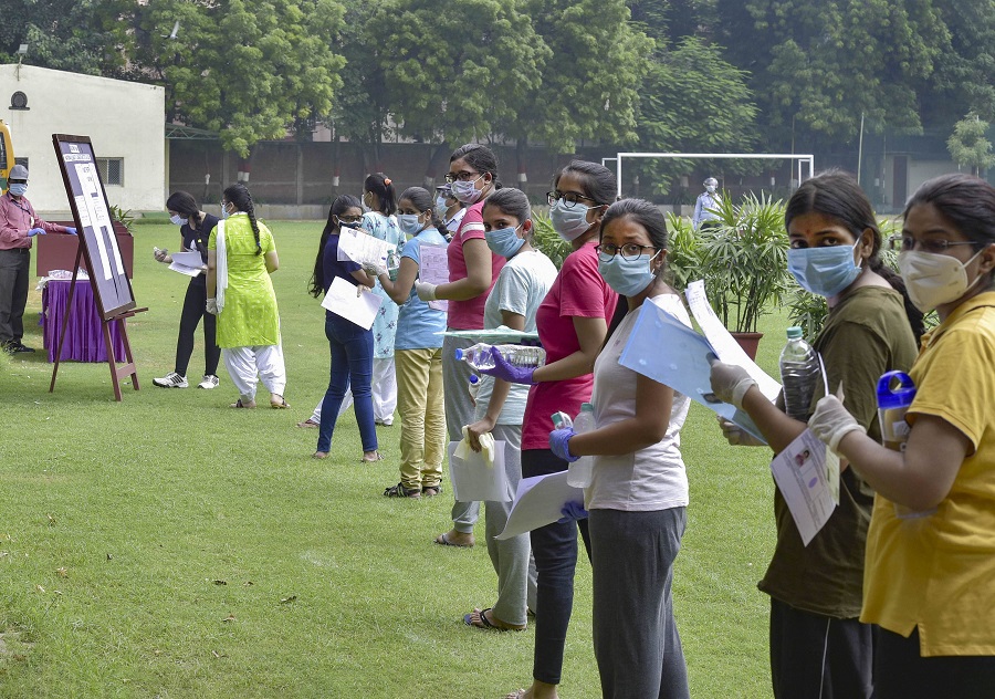  Aspirants wearing masks stand in a queue at an examination centre for National Eligibility cum Entrance Test (NEET), in New Delhi, Sunday, Sept. 13, 2020.