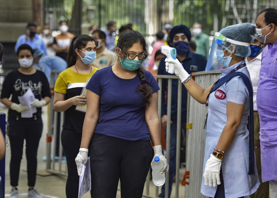  Aspirants undergo thermal screening as they enter an examination centre for appearing in the National Eligibility cum Entrance Test (NEET) in New Delhi, Sunday, Sept. 13, 2020. 