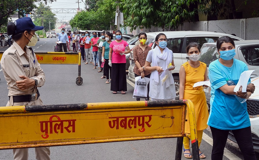 Candidates wait outside an examination centre before appearing in the National Eligibility cum Entrance Test (NEET), during unlock 4.0, in Jabalpur, Sunday, Sept. 13, 2020. 