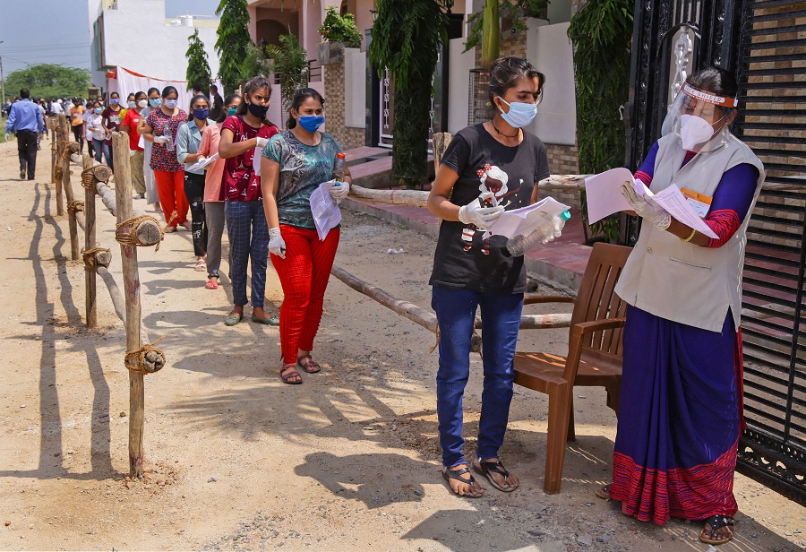 Candidates wearing masks stand in a queue at an examination centre before appearing for the National Eligibility cum Entrance Test (NEET) during unlock 4. o, in Beawar, Sunday, Sept. 13, 2020.