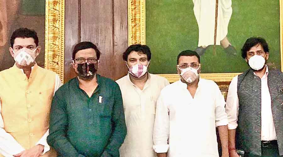 Suresh Pujari (in green kurta) with other MPs wearing Sambalpuri masks in Parliament on Monday