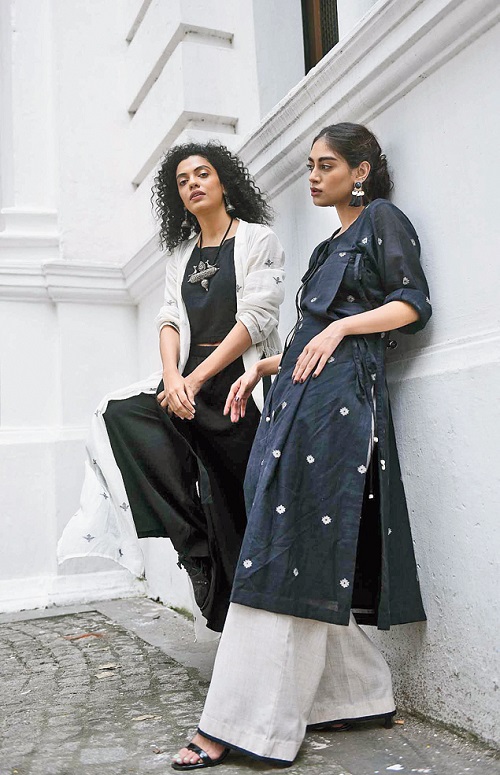 5. This black-and-white jamdani collection is all about the magic of mix-and-match layered with plenty of campus crispness. Subhamita’s white jamdani throw paired with a crop top and a pair of palazzo is Sayantan’s ode to jackets. “I love jackets as it does the trick for the entire outfit. It is an interesting interplay of structure and form,” says Sayantan, who fell in love with jackets after his visit to Italy. Black patent brogues, silver earrings and a heavy silver neckpiece complete the “simple yet dramatic” look. Olivia will keep this one aside for a sundowner. Bibriti’s angarkha-style black-and-beige jamdani kurta is striking. “The neckline is made interesting with a fold of a fabric. You can wear it as a dress too,” says Sayantan. Bibriti sports it with structured pants, golden tasselled earrings and black stilettos. The heritage backdrop of the Currency Building complements the languid modernity of the silhouettes.