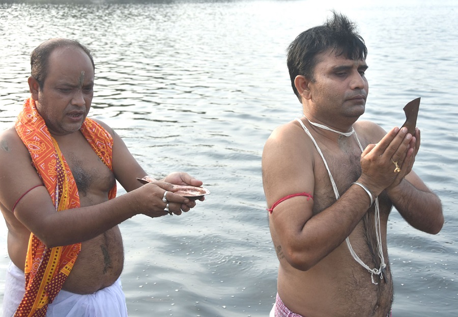 People perform the ritual of tarpan to offer prayer to their ancestors on the occasion of Mahalaya at Loco Tank (pond) in Hirapur, Dhanbad on the occassion of Thursday. 