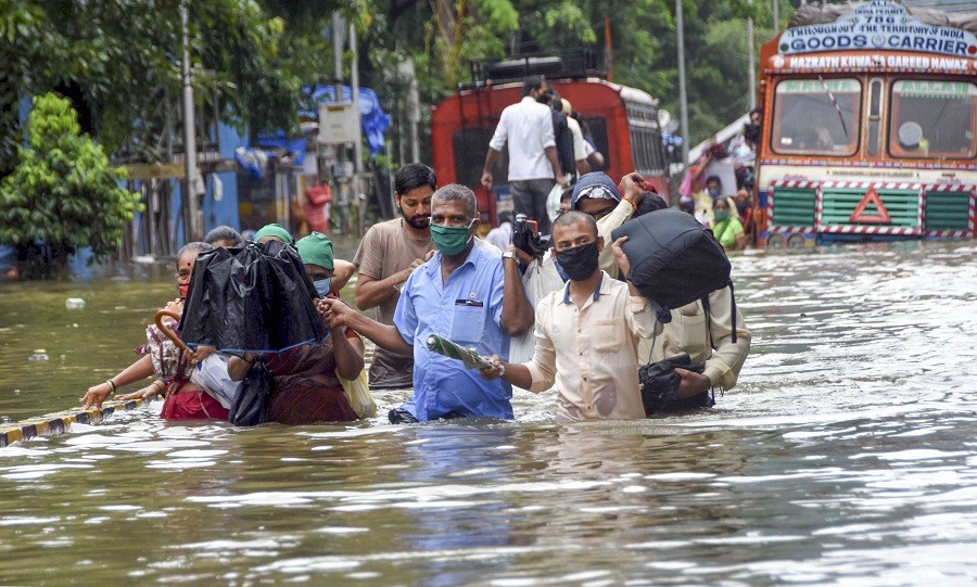 People wade through a waterlogged street at Parel area in Mumbai on Wednesday.