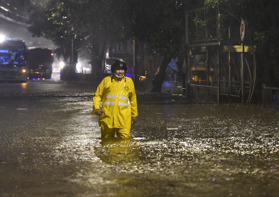 A policeman wades through a waterlogged street after heavy monsoon rain at Sion in Mumbai, on the wee hours of Wednesday.