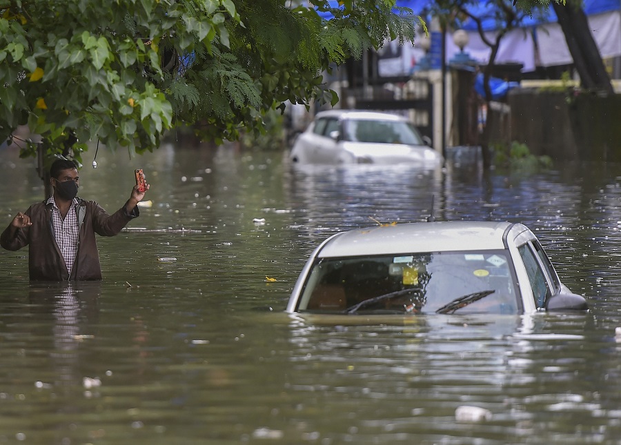 A man wades through a waterlogged street at Sion in Mumbai on Wednesday.
