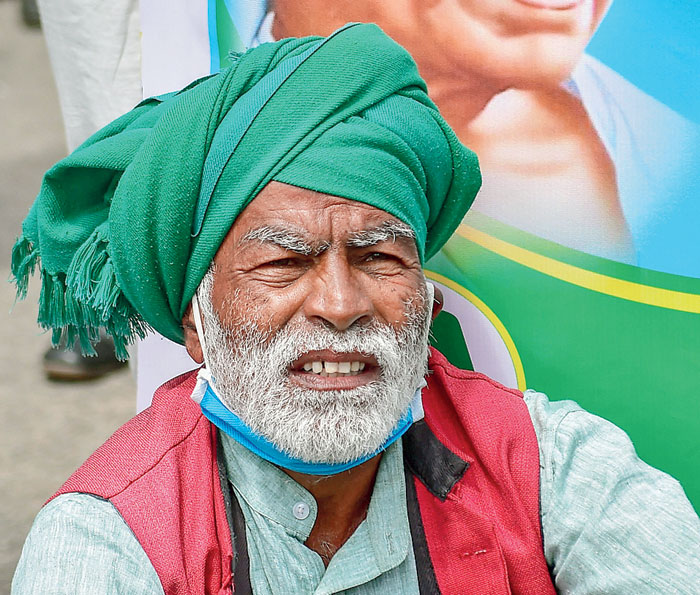 A farmer listens to a speech during a protest against the bills in Bangalore on Friday.