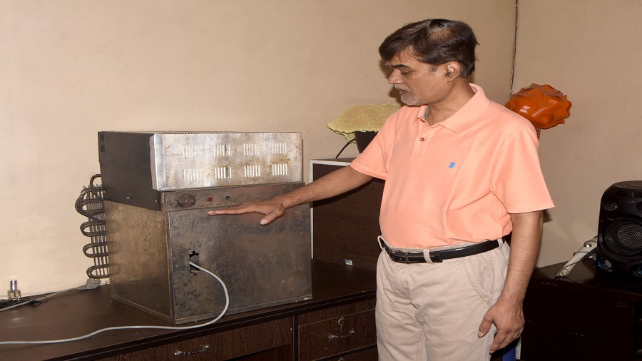 Uday Thakur with his new creation, an ‘atmospheric water generator’ at his residence in Dhanbad on Wednesday