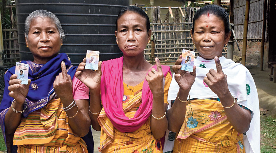 Tribal community women  show their fingers after casting their votes at Sildubi in Morigaon district on Thursday.