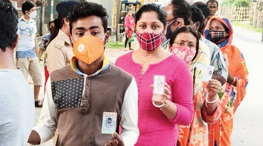 Voters queue up to vote at a booth in Cooch Behar district.