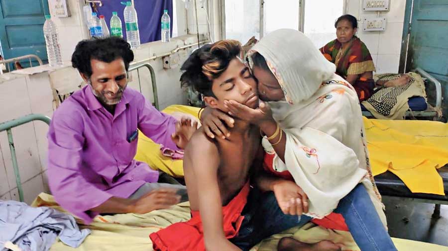 Mrinal Haque, with his parents Majid Mia and Rahila Bibi, at the subdivisional hospital in Mathabhanga on Sunday. 