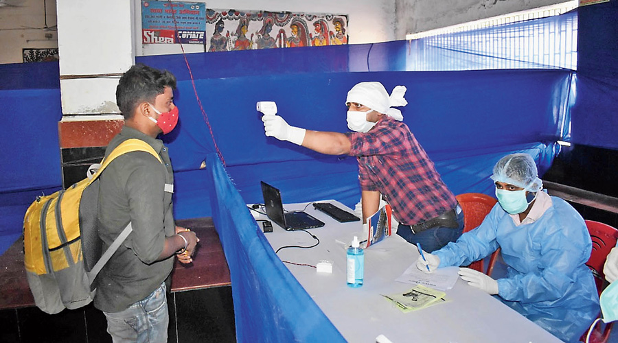 An official checks temperature with a thermal scanner at Sitamarhi railway station on Monday. 