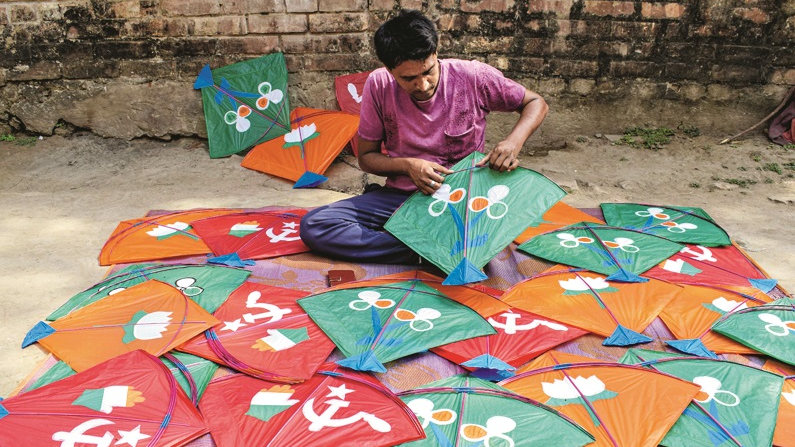 A kite-maker makes kites with symbols of political parties, in the view of Assembly polls, in Nadia district, Saturday, March 27, 2021.