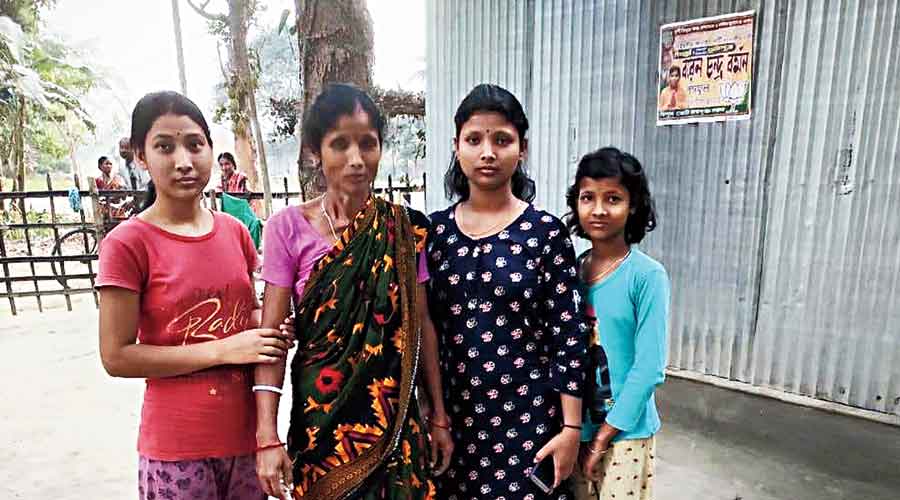 Minati Burman (in saree), the health worker deputed  at the booth to screen voters