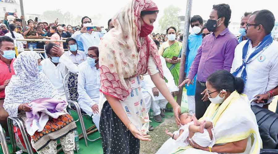 Mamata holds baby Mariam, whose father was killed in the Sitalkuchi firing, as her  mother looks on in Mathabangha on Wednesday