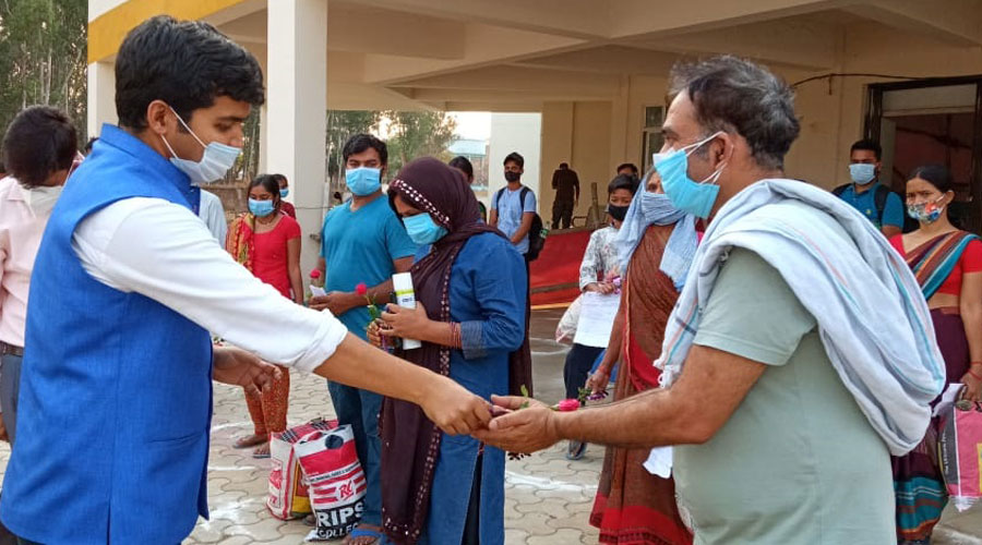 SDM Manish Kumar gives a rose to a man who was diacharged from hospital after recovering from Covid-19 in Koderma on Friday.