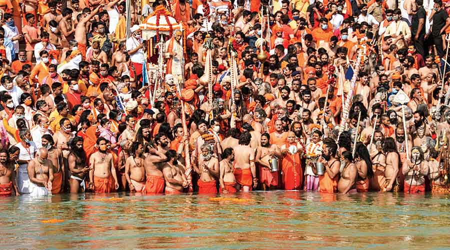 Devotees gather to offer prayers during the third 'Shahi Snan' of the Kumbh Mela 2021 