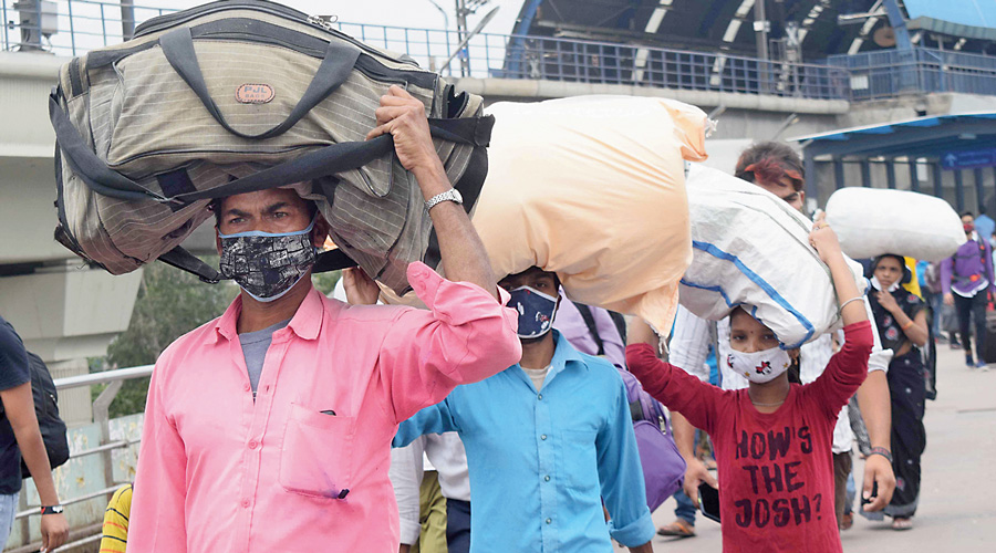 Migrants prepare to board buses out of Delhi on Tuesday.