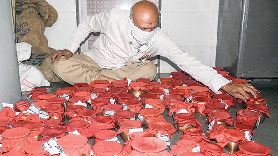 A volunteer packs urns with ashes of  Covid-19 victims in Surat on April 14 to  be taken to Haridwar. 