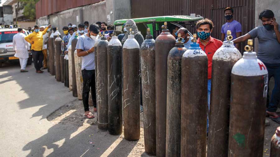 Family members of Covid-19 patients wait to  refill cylinders with medical oxygen at a plant in  Lucknow on April 20. 