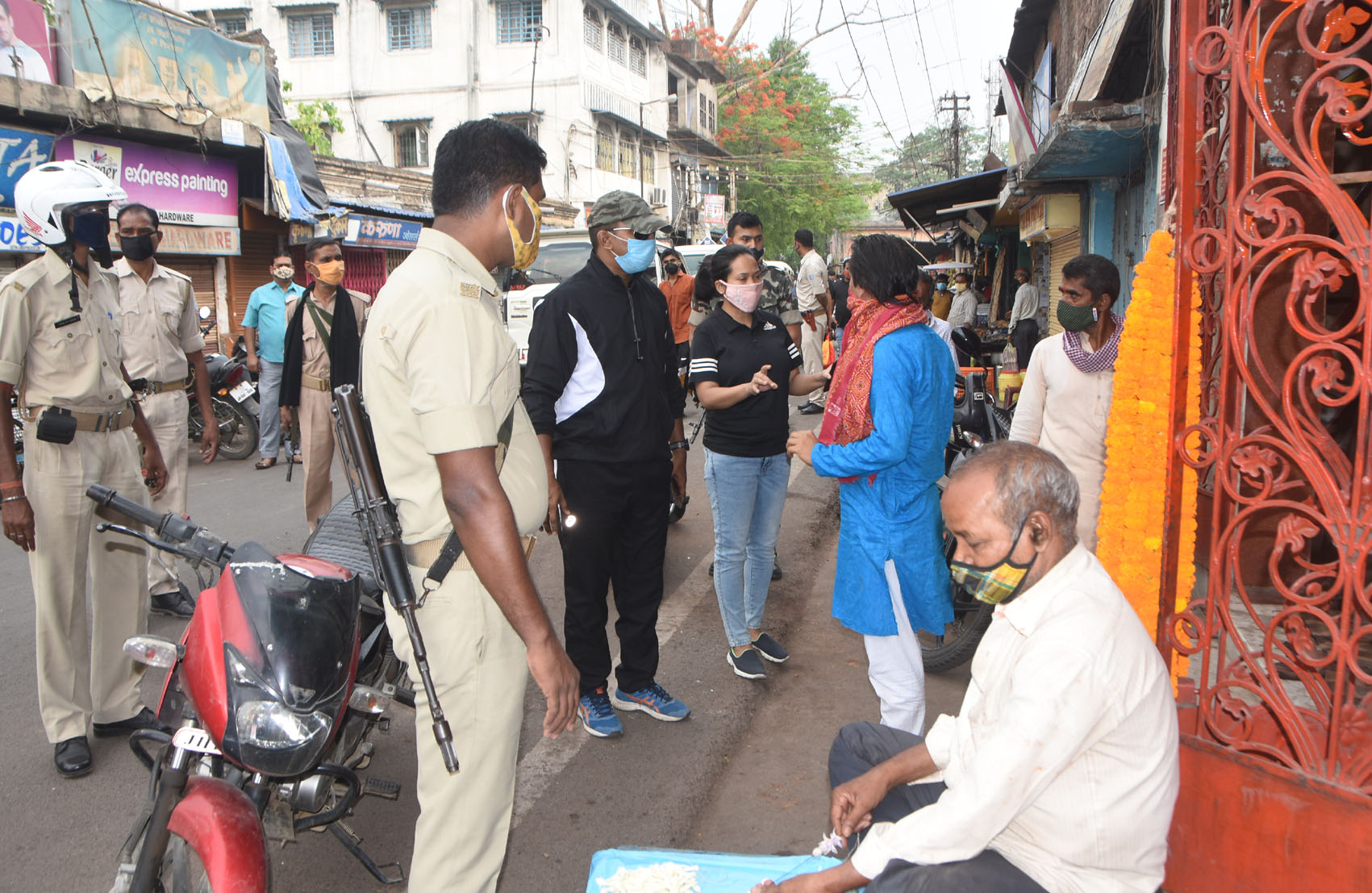 Dhanbad Superintendent of Police R Ramkumar (in tracksuit) and Deputy Superintendent Sarita Murmu (in black T-shirt) remind a priest to follow the protocols of the lockdown, at Hirapur Hatia Road on Thursday.