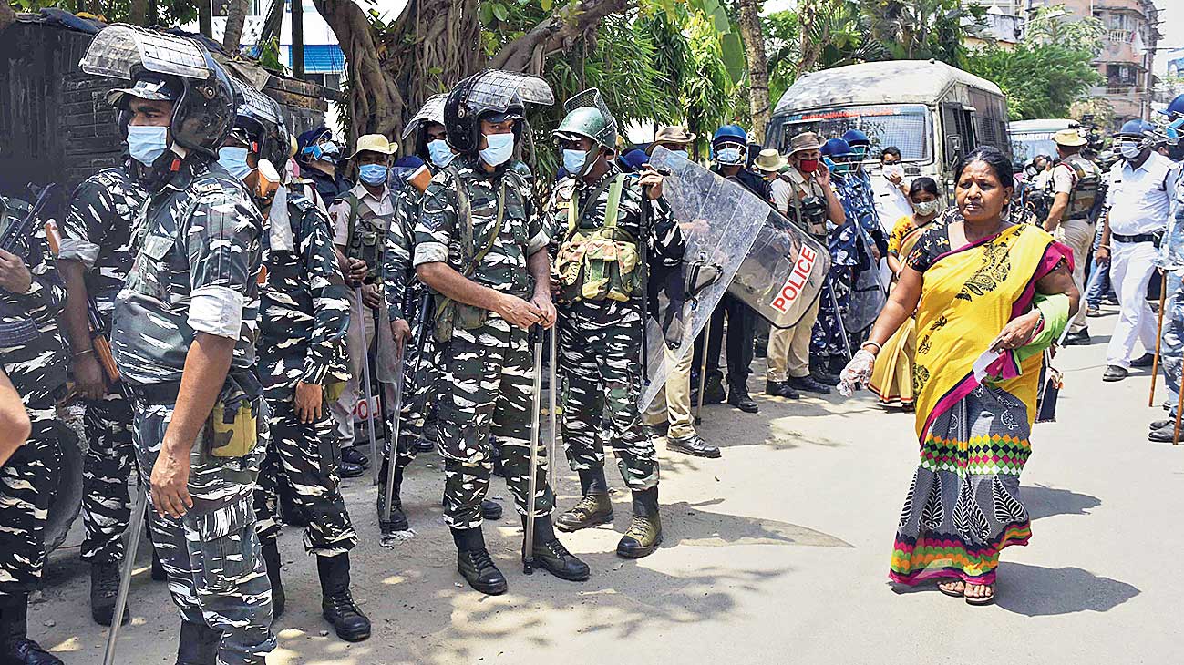 Police, RAF and Central Force QRT march at Shantinagar after a clash between TMC and BJP supporters on election day 
