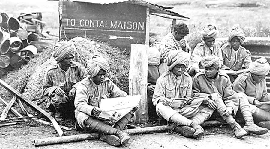 Members of an Indian Labour Battalion reading papers during a work break, 1917