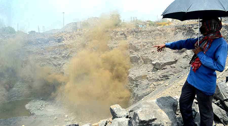 A worker showing the smoke out from a mine of Bharat Coking Coal Limited at North Tisra in Jharia on Friday.