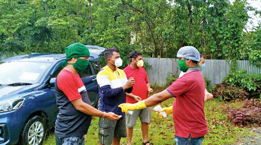 An employee of a private resort in Madarihat of Alipurduar district dispenses sanitiser to visitors before check-in.  