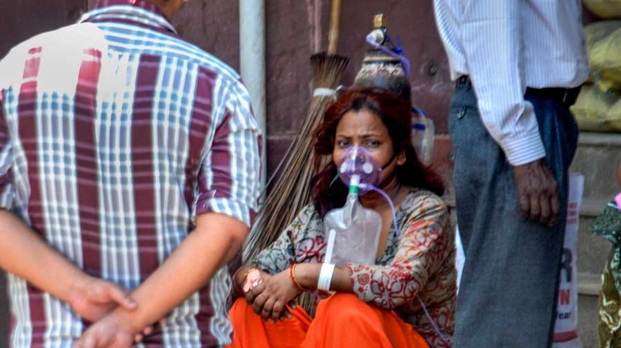 A woman sitting with an oxygen mask in Agra on Sunday.