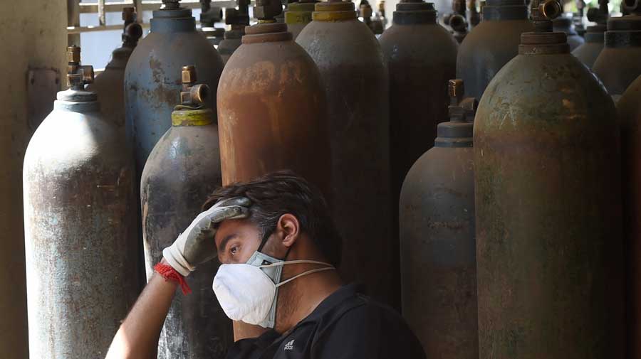 A relative of a Covid patient waits to get a refill of the oxygen cylinder at Badarpur in New Delhi on Sunday