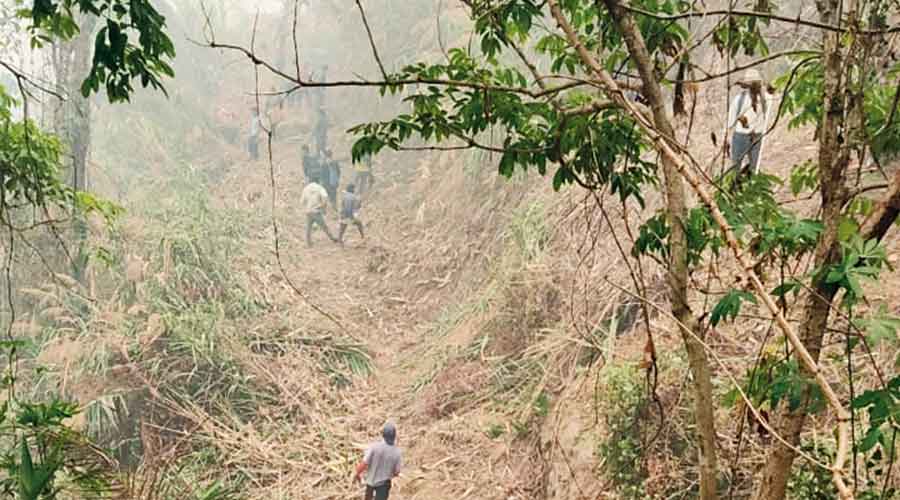 Community volunteers cut a fireline to check the spread of the fire