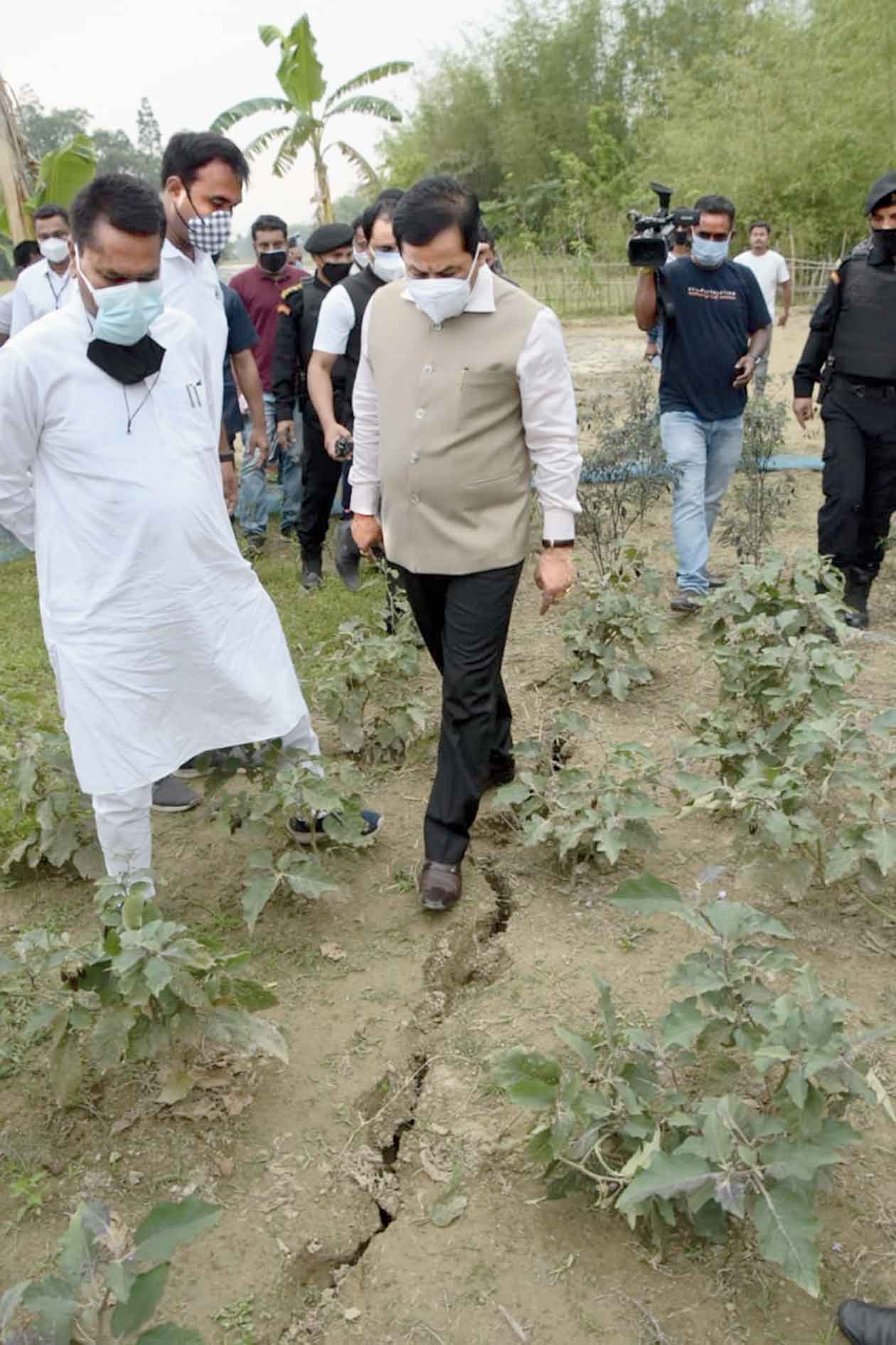 Sonowal examines a crack in the ground caused by the tremors in Dhekiajuli