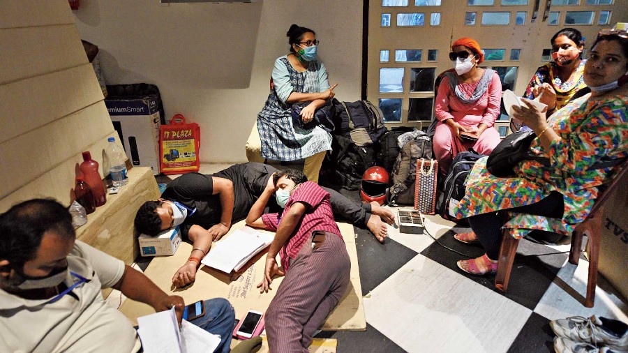 Polling officials take a break from work at Netaji Indoor Stadium on Wednesday. 