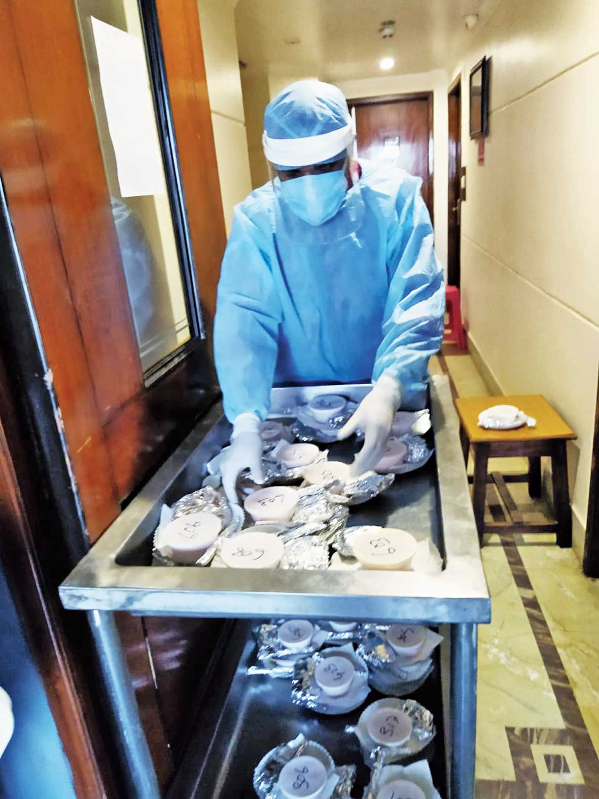 Snacks being taken to Covid patients in isolation at Hotel The Sojourn by a PPE-clad staff member