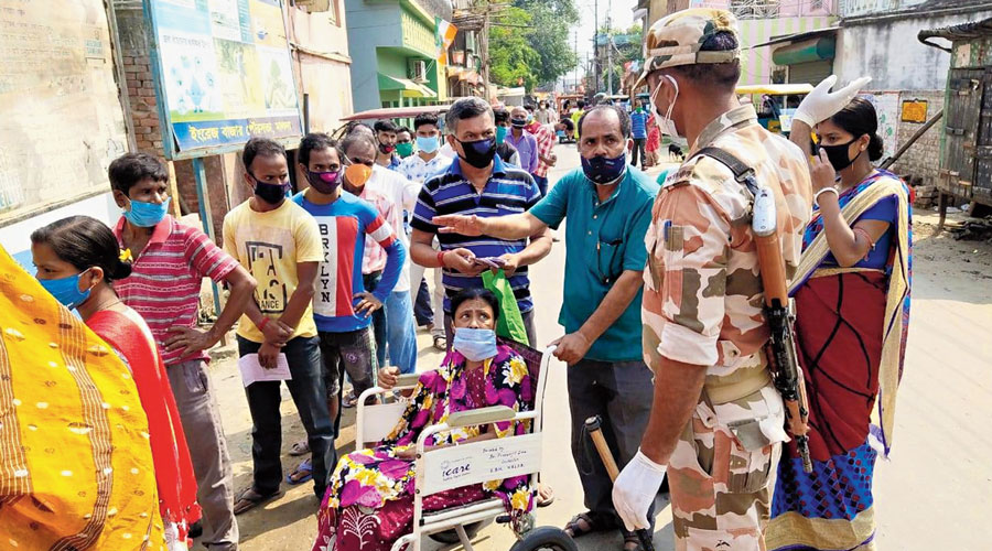 A sick woman being taken to a booth on a wheel-chair in Malda on Thursday.