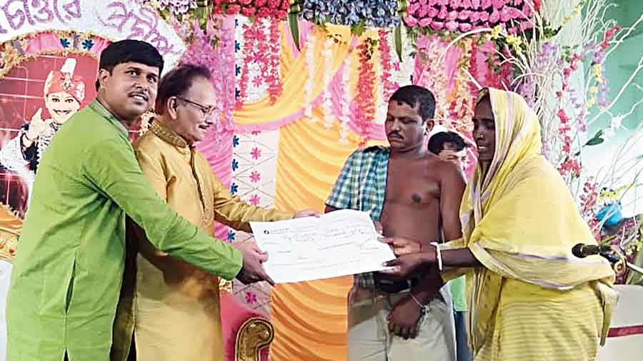 Ujjwal (in green) and PC Sorcar Jr hand over a cheque to the Shee couple