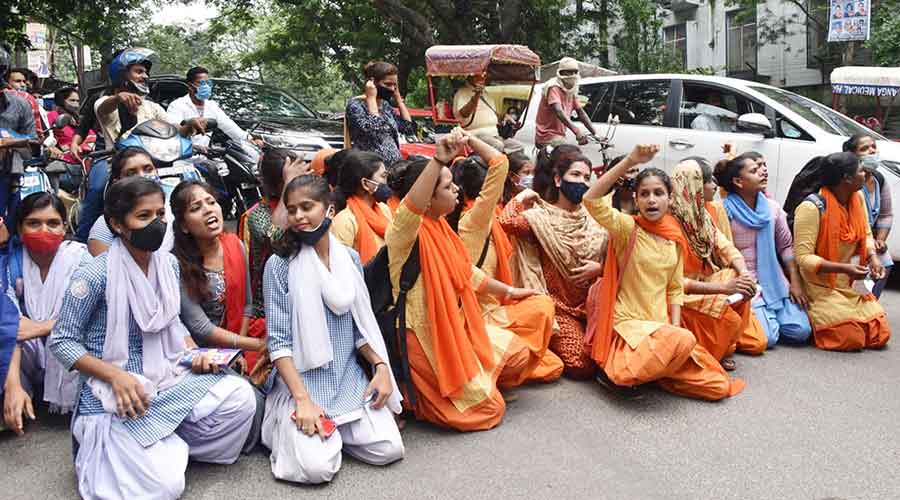 Students of SSLNT Women’s College block the main road in front of the campus in protest against their results in Dhanbad on Monday.