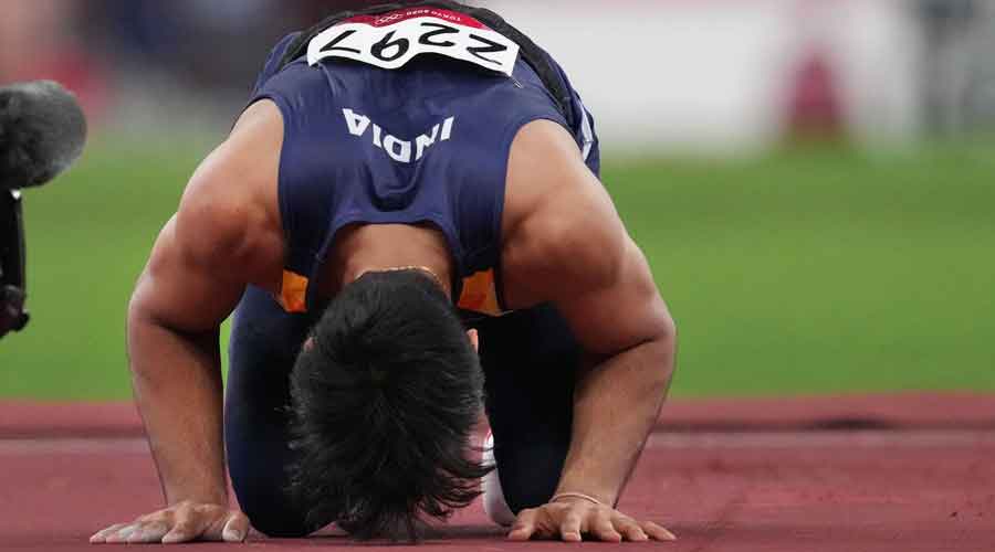Neeraj Chopra bows down on the track after winning in the final of the men's javelin throw event at the 2020 Summer Olympics, in Tokyo, on Saturday.