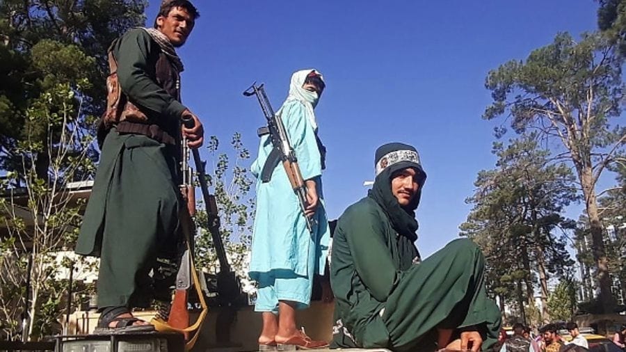 Taliban fighters stand on a vehicle along the roadside in Herat, Afghanistan's third biggest city, on Thursday.