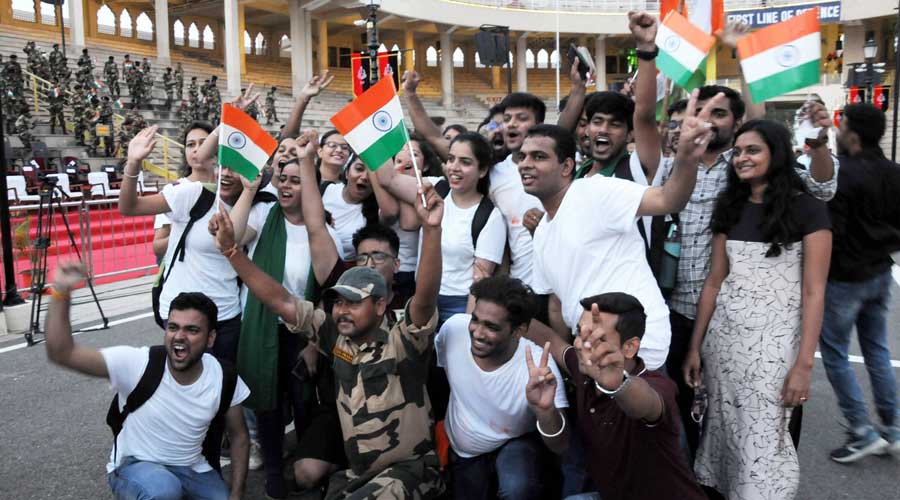 Visitors pose with the national flags during a ceremony on the occasion of 75th Independence Day, at the Attari-Wagha border