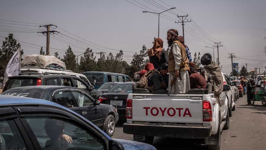 Armed members of the Taliban ride in a truck in Kabul, Afghanistan on Wednesday, Aug. 18, 2021. The Taliban have sought to present a kinder and gentler image of an Islamic Emirate of Afghanistan to the world, but scenes near the airport offered a bloody counterpoint.
