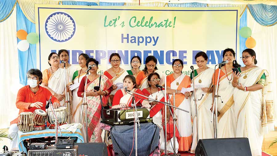 A group of women sings at the Balaka event in BD Park. (Below) Little Aditri Bhattacharya with the Tricolour in hand