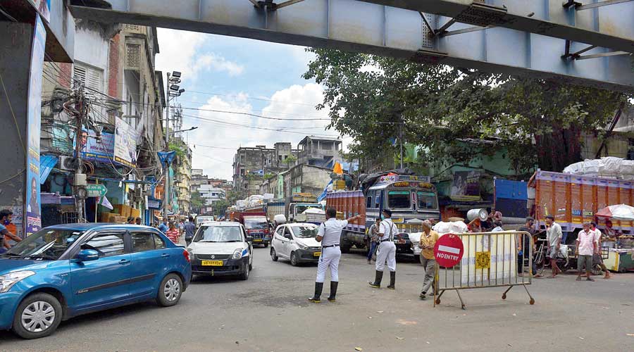 Traffic police direct vehicles in the absence of signage on Maharsi Debendra Road, informing motorists about the closure of Vivekananda Road on Saturday