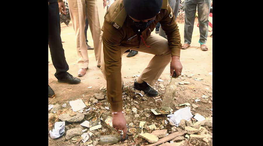 A policeman removes liquor bottles from the Assembly premises on Tuesday. 