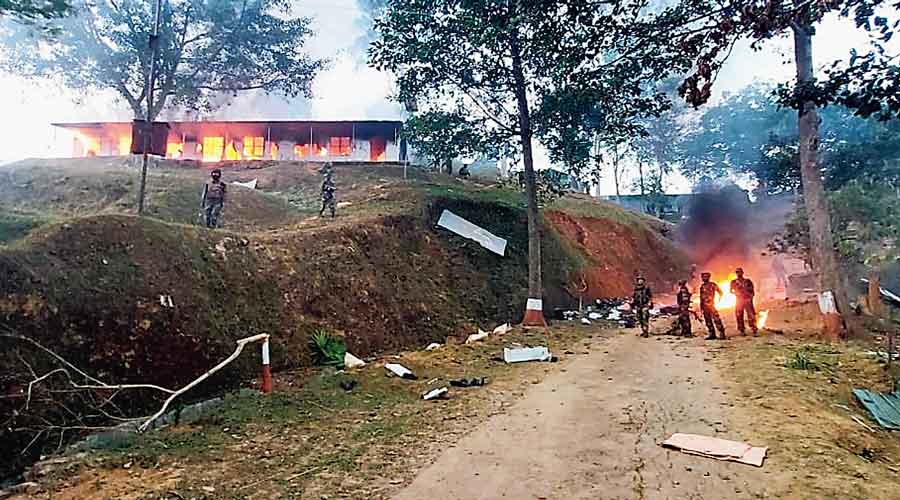 Assam Rifles soldiers stand near their burning camp on Sunday after protesters set it on fire over the civilian  killings in Nagaland’s Mon district.